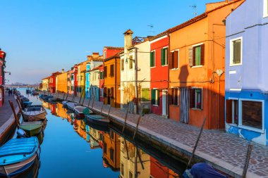 İtalya, Venedik 'teki Burano adasında renkli binaları olan bir cadde. Burano 'nun mimarisi ve simgeleri, Venedik kartpostalı. Venedik, İtalya yakınlarındaki Burano adasında manzara kanalı ve renkli mimari