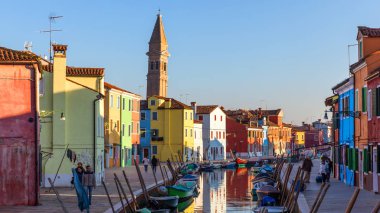 İtalya, Venedik 'teki Burano adasında renkli binaları olan bir cadde. Burano 'nun mimarisi ve simgeleri, Venedik kartpostalı. Venedik, İtalya yakınlarındaki Burano adasında manzara kanalı ve renkli mimari