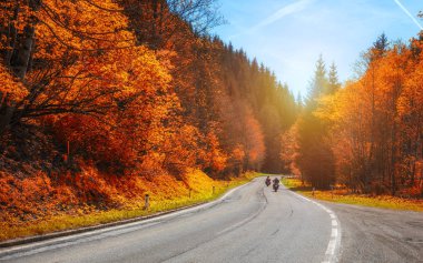 Bisikletçileri dağlık karayolu, motorcu eğri yolda sürme sonbahar günbatımı ışıkta de yol üzerinde geçmek Alp Dağları, aşırı yaşam tarzı, Özgürlük kavramı arasında. Avusturya, Alpler
