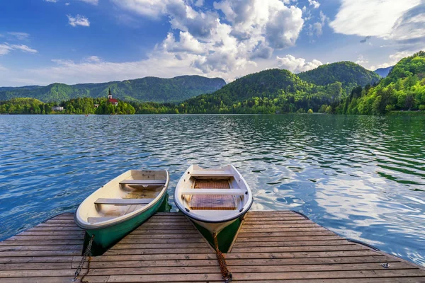 Iconic Bled scenery. Boats at lake Bled, Slovenia, Europe. Wooden boats with Pilgrimage Church of the Assumption of Maria on the Island on Lake Bled, Slovenia