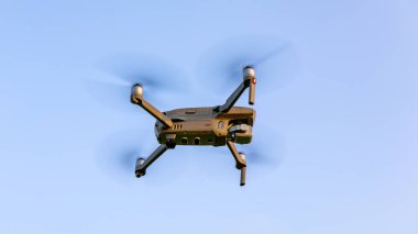 Peyzaj üzerinde uçan uçak. Digital fotoğraf makinesi ile uçan Uav uçağı helikopter. Ek yükü bulutlu mavi gökyüzünde uçan robot. Dört helikopter alan üzerinde uçuyor.