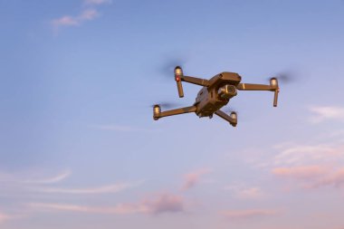 Peyzaj üzerinde uçan uçak. Digital fotoğraf makinesi ile uçan Uav uçağı helikopter. Ek yükü bulutlu mavi gökyüzünde uçan robot. Dört helikopter alan üzerinde uçuyor.