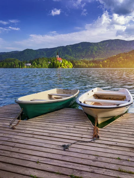 Iconic Bled scenery. Traditional wooden boats Pletna at lake Bled, Slovenia, Europe. Wooden boats with Pilgrimage Church of the Assumption of Maria on the Island on Lake Bled, Slovenia