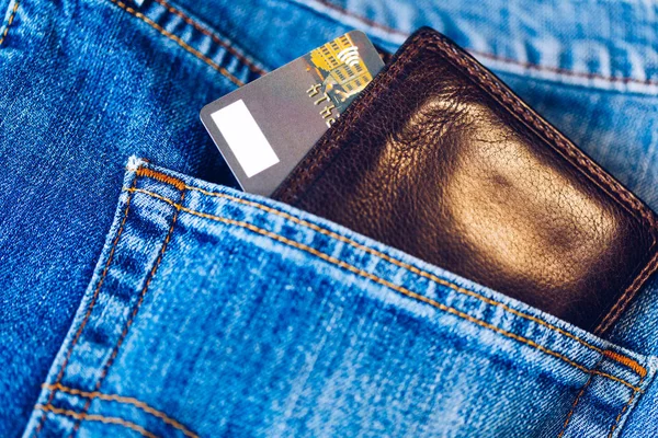 Credit card in wallet in pocket of jeans, closeup. Closeup of wallet and credit card in jeans trousers pocket.