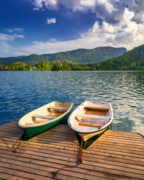 Iconic Bled scenery. Boats at lake Bled, Slovenia, Europe. Wooden boats with Pilgrimage Church of the Assumption of Maria on the Island on Lake Bled, Slovenia