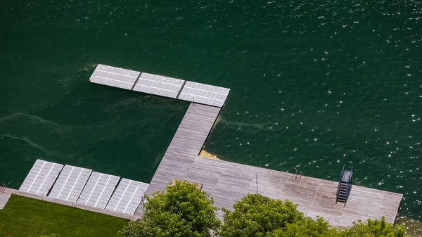 Empty wooden pier close to Bled lake, swimming area of the Bled lake under the sunny sky. Platform beside lake. Wooden pier on the lake. Bled, Slovenia