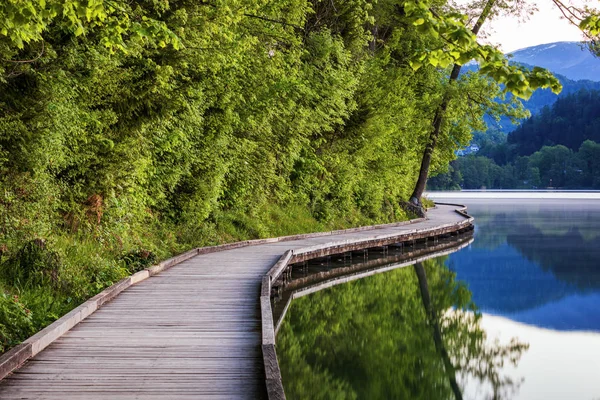 A Bledi-tó és a házak körül fa gyalogjárda — Stock Fotó