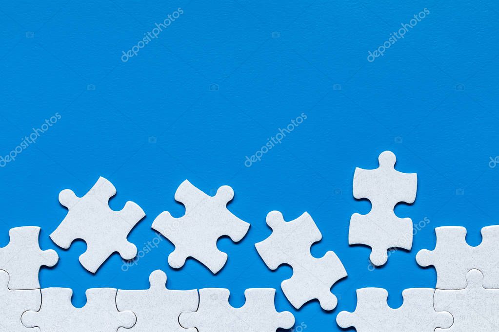 White jigsaw puzzle. White puzzle pieces on color background. Un