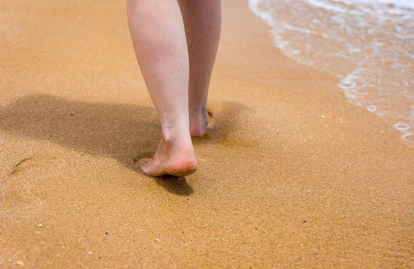 Kvinnan går barfota på en strand. Närbild ben av ung kvinna w — Stockfoto