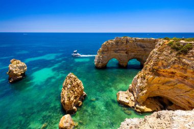 Marinha plajında doğal mağaralar, Algarve Portekiz. Kayalık yay