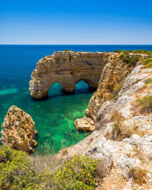 Marinha plajında doğal mağaralar, Algarve Portekiz. Kayalık yay