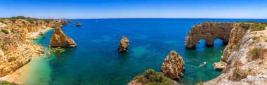 Marinha plajında doğal mağaralar, Algarve Portekiz. Kayalık yay