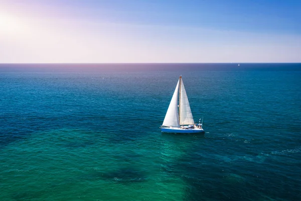 White sail boat isolated in blue sea water. Sailboat in the sea — Stock Photo, Image