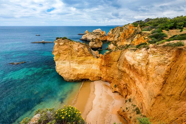 Pohled na omračující pláž se zlatými barevnými kameny ve městě Alvor, A — Stock fotografie