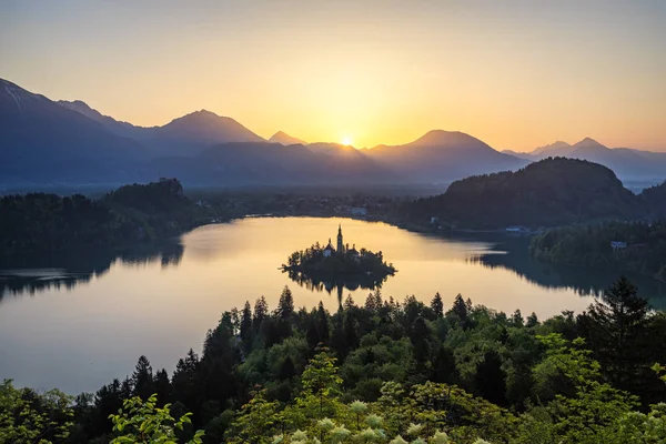 Slowenien blutete aus. schöner Sonnenaufgang über dem See mit kleinem — Stockfoto
