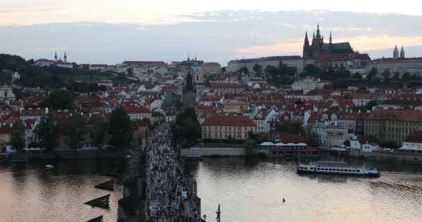 De Praagse burcht en de Karelsbrug bij zonsondergang in Praag, Tsjechische Republiek, Moldau op voorgrond — Stockvideo