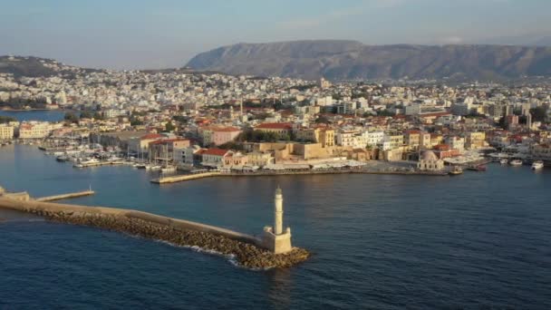 Aerial drone video of iconic Venetian lighthouse in the entrance of picturesque old port of Chania with beautiful colours, Crete island, Greece. Lighthouse in Chania. Lighthouse of the city of Chania. — Stock Video