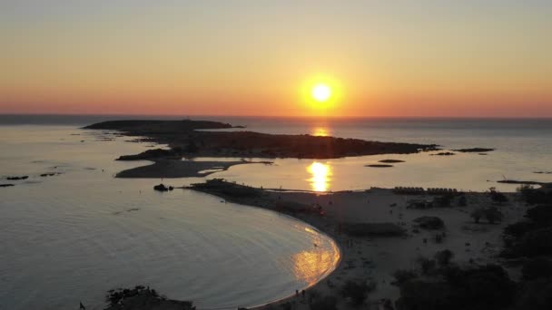 Воздушный беспилотник с панорамным видом на знаменитый экзотический райский песчаный изумрудный пляж Элафонисси на острове Юго-Западный Крит, Греция. Вид на закат голубого пляжа Элафисси на Крите, Греция . — стоковое видео