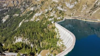 Fedaia gölü barajı (Fedaia gölü), Marmolada masif, Dolomites, Trentino eteklerinde bulunan Canazei yakınlarındaki yapay bir göl. İtalya'nın Dolomites bölgesinde Fedaia Barajı'nın havadan drone görüntüleri.