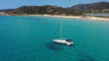 Güneşli bir günde gölde yat. Yelkenli. Deniz yatı, hava fotoğrafçılığı dronu. İnanılmaz bir yat ya da turkuaz ve şeffaf denizi olan bir yelkenli. Mavi göldeki yelkenli teknelerin üst görüntüsü