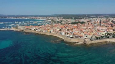 Alghero 'nun eski şehri üzerinde hava görüntüleri, güzel bir günde şehir manzarası, liman ve açık deniz manzaralı. Alghero, İtalya. Alghero, Sardinya, İtalya 'nın panoramik hava manzarası. 