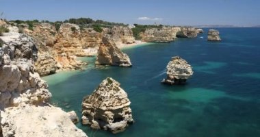 Marinha sahilindeki doğal mağaralar, Algarve Portekiz. Marinha sahilindeki kayalık kemerleri ve Algarve bölgesindeki Portekiz kıyılarındaki turkuaz deniz suyu..