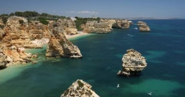 Marinha sahilindeki doğal mağaralar, Algarve Portekiz. Marinha sahilindeki kayalık kemerleri ve Algarve bölgesindeki Portekiz kıyılarındaki turkuaz deniz suyu..