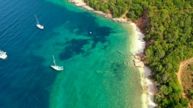 Zümrüt denizdeki demirli yelkenli yatının havadan görünüşü. Bir teknenin havadan görünüşü. Açık deniz sporları, yat. Açık denizde demirleyen yatın havadan görüntüsü. Okyanus ve deniz yolculuğu ve ulaşım