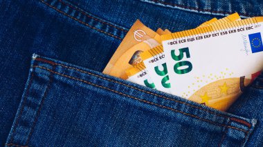 Kot pantolon cebinde Avro faturaları. Kotun arka cebindeki Euro banknotları. Zengin insan kavramı, para biriktirmek ya da harcamak. Avro faturaları düşüyor. Parayı çalmak kolay. Sorumsuzca hareket.