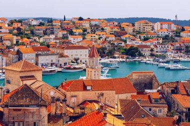 Trogir in Croatia, town panoramic view with red roof tiles, Croatian tourist destination. Trogir town sea front view, Croatia. Roofs of Trogir in Croatia. clipart