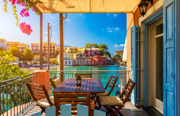 Assos, Kefalonia adasında çiçekli Yunan evleri olan geleneksel cadde. Assos köyündeki geleneksel renkli Yunan evleri. Çiçek açan fuşya çiçekleri. Kefalonia Adası, Yunanistan