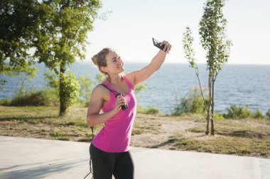 Kız parkta eğitimden sonra selfie yapar.