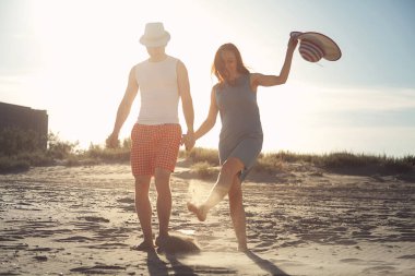 Kum plajında holding çevresinde yürüyüş eğlenceli eller çift olan sevgi dolu güzel.
