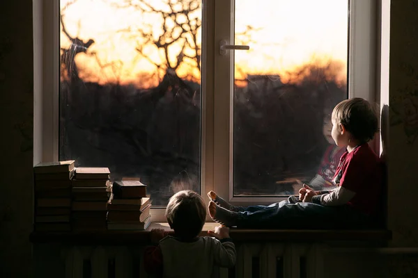 Двоє Хлопців Дивляться Вікно Підвіконні Книжки Вечірнє Сонячне Світло Освітлює — стокове фото