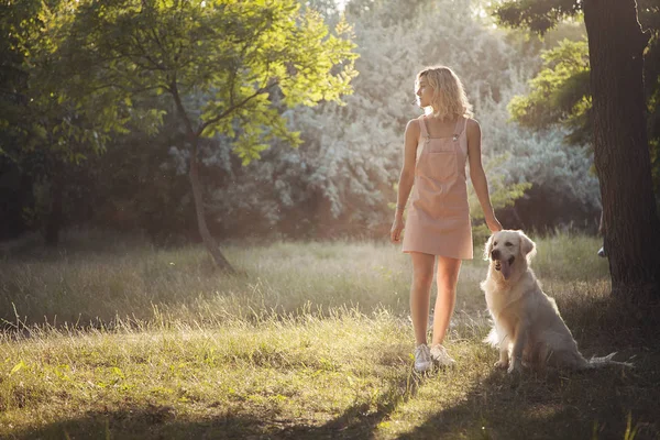 Bir kız ve bir köpek parkta yürüyorlar..