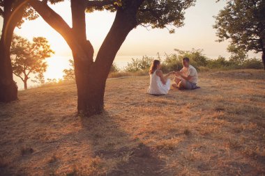 Parkta oturan genç bir çift. Erkek ve kadın romantik ilişki.