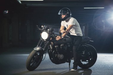 Bir motosiklet bir park yerinde bir bisikletçinin portresi.