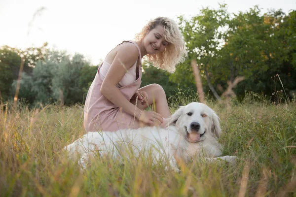 一只金色的猎犬和一个白头发的女孩在公园里散步 — 图库照片