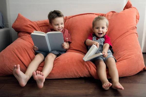 Dois Rapazes Sentam Com Livros Numa Poltrona Macia Irmãos Familiares — Fotografia de Stock