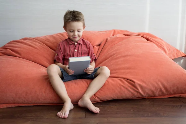 Ein Süßer Junge Liest Ein Buch Auf Der Couch — Stockfoto