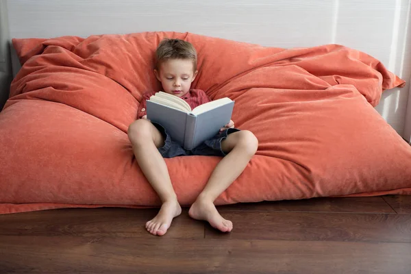 Söt Pojke Läser Bok Soffan — Stockfoto