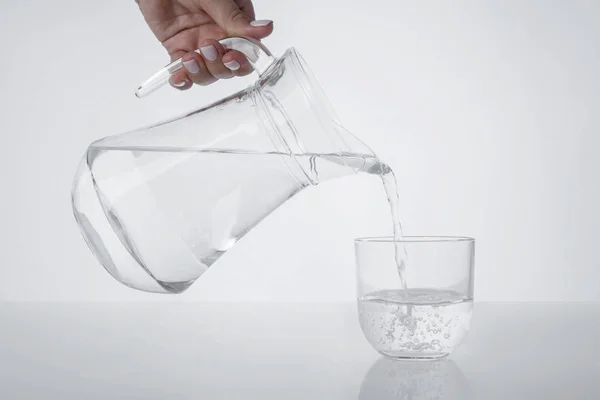 Bir bardak, sürahi ve kristal berraklığında su.