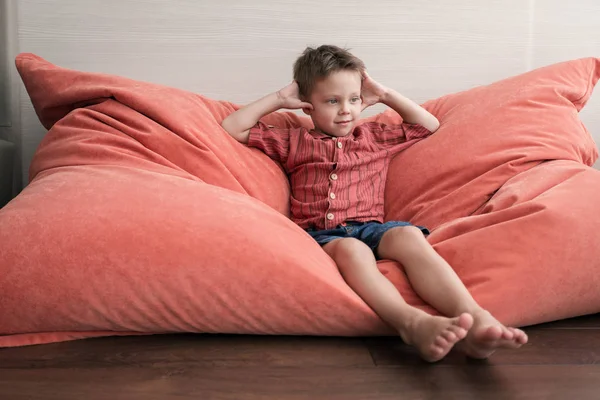 Ein Hübscher Junge Sitzt Auf Einem Weichen Sessel Zimmer — Stockfoto