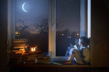 Çocuk gece yıldızlar ve rüyalar pencere kenarında oturur.