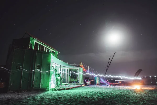 Container house at night on the shore. Youth disco.