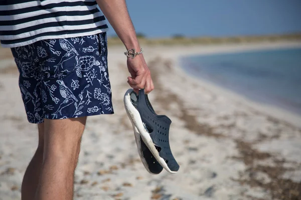 Joven Está Playa Sosteniendo Zapatillas Sus Manos — Foto de Stock