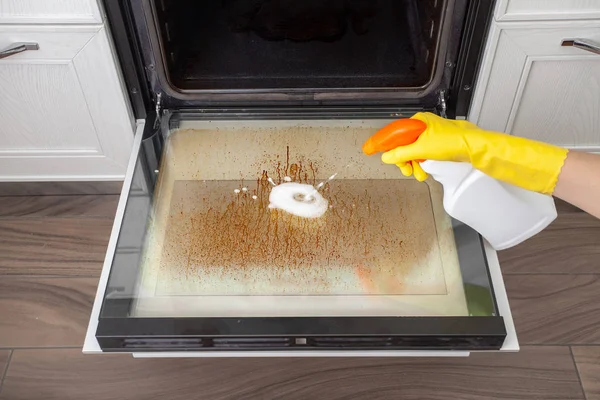 Kirli fırın kapağı mutfakta. Temizleme ve toplama için cihazlar.