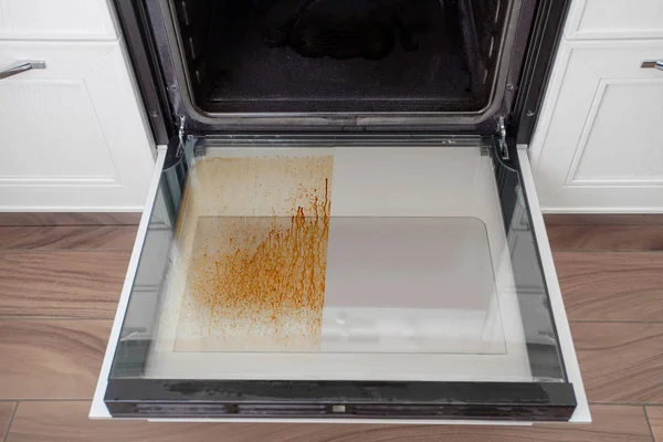 Kirli fırın kapağı mutfakta. Temizleme ve toplama için cihazlar.