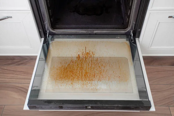 Kirli fırın kapağı mutfakta. Temizleme ve toplama için cihazlar.