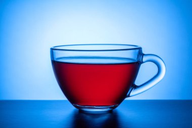 Parlak renkli arka plan üzerinde bir içkiyle cam saydam Kupası.